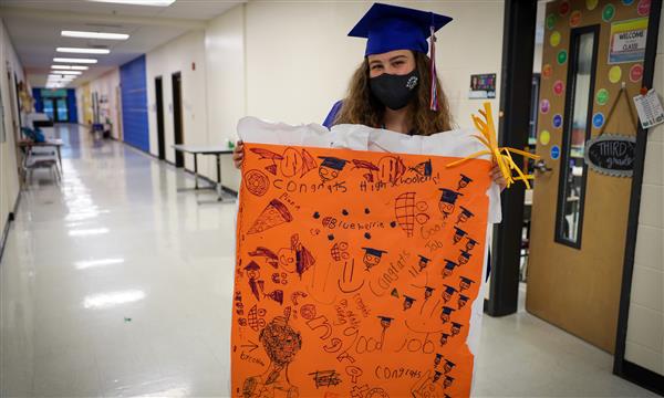 Senior holds up congratulations sign